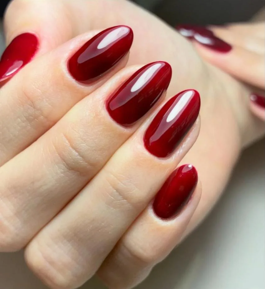 Unhas amendoadas esmaltadas em vermelho escuro